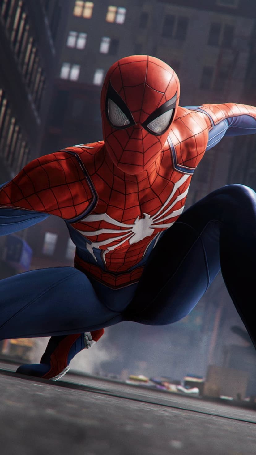 Spider-Man in a red and blue suit crouches on a building ledge with a blurred city skyline and lights behind him.