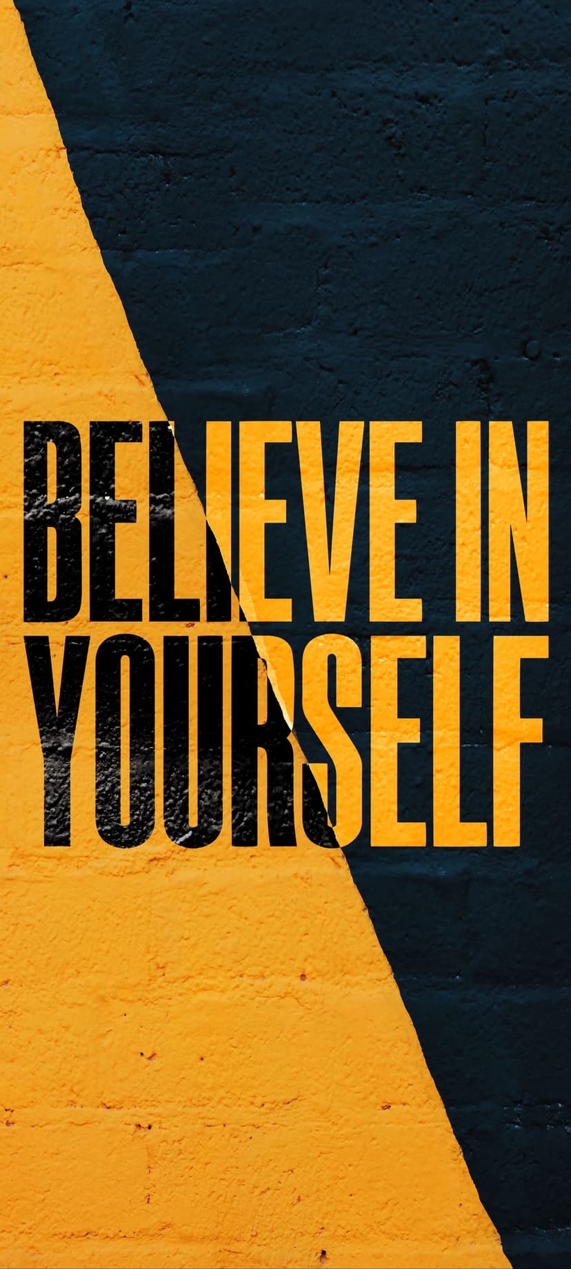 Believe in Yourself text painted in black and yellow over a textured brick wall with a diagonal split design.