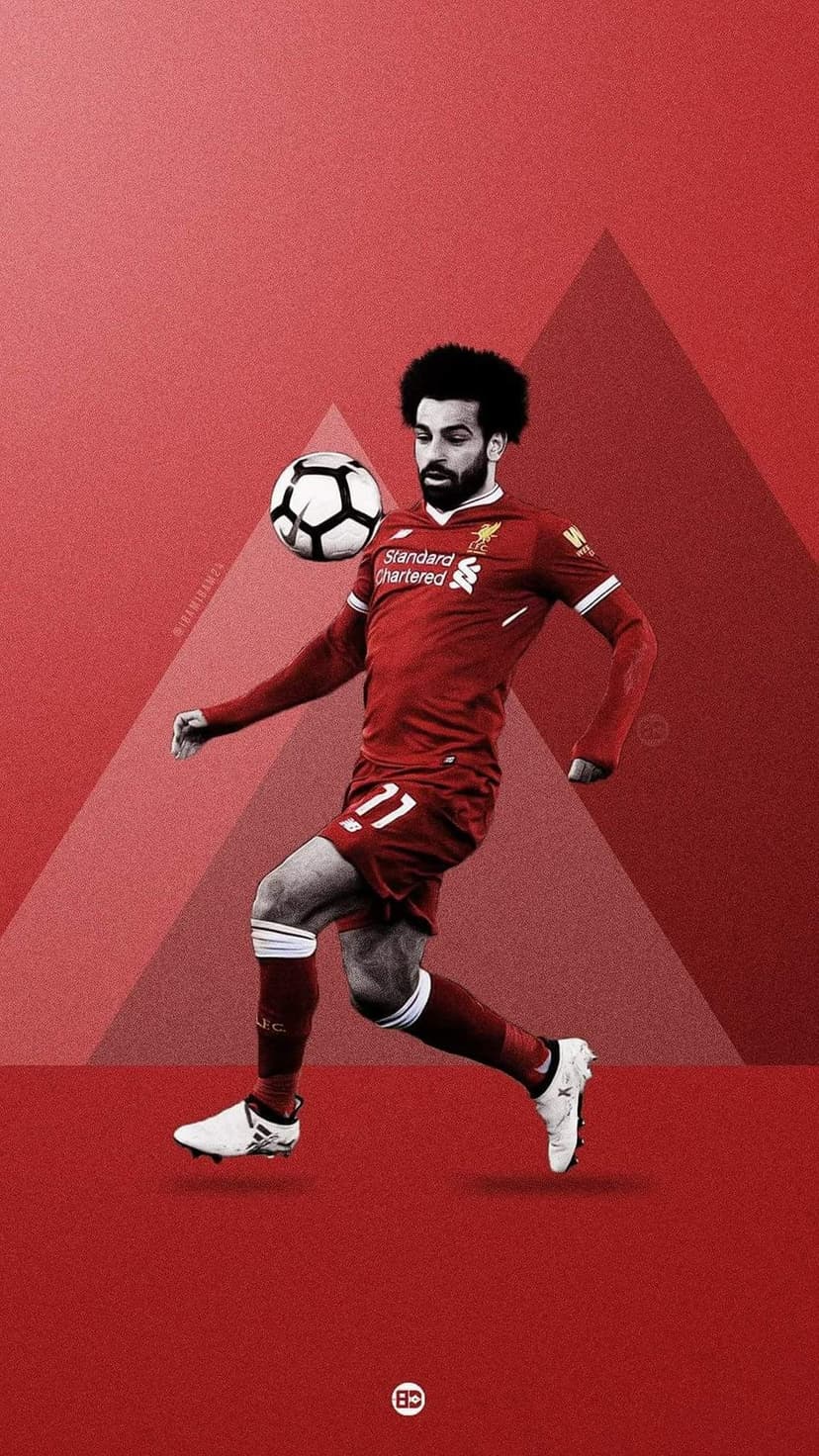 Mohamed Salah balances a football on his foot against a red geometric background in a vertical sports portrait.