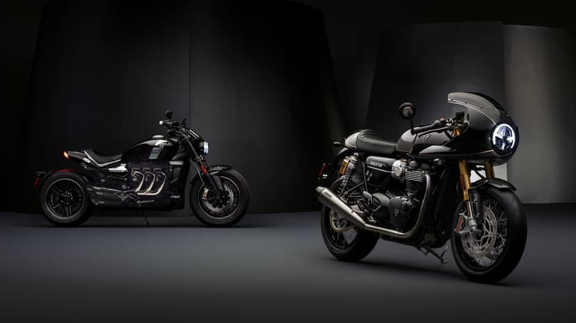 Two black Triumph TFC motorcycles in a dark studio with dramatic lighting and glowing LED headlights.