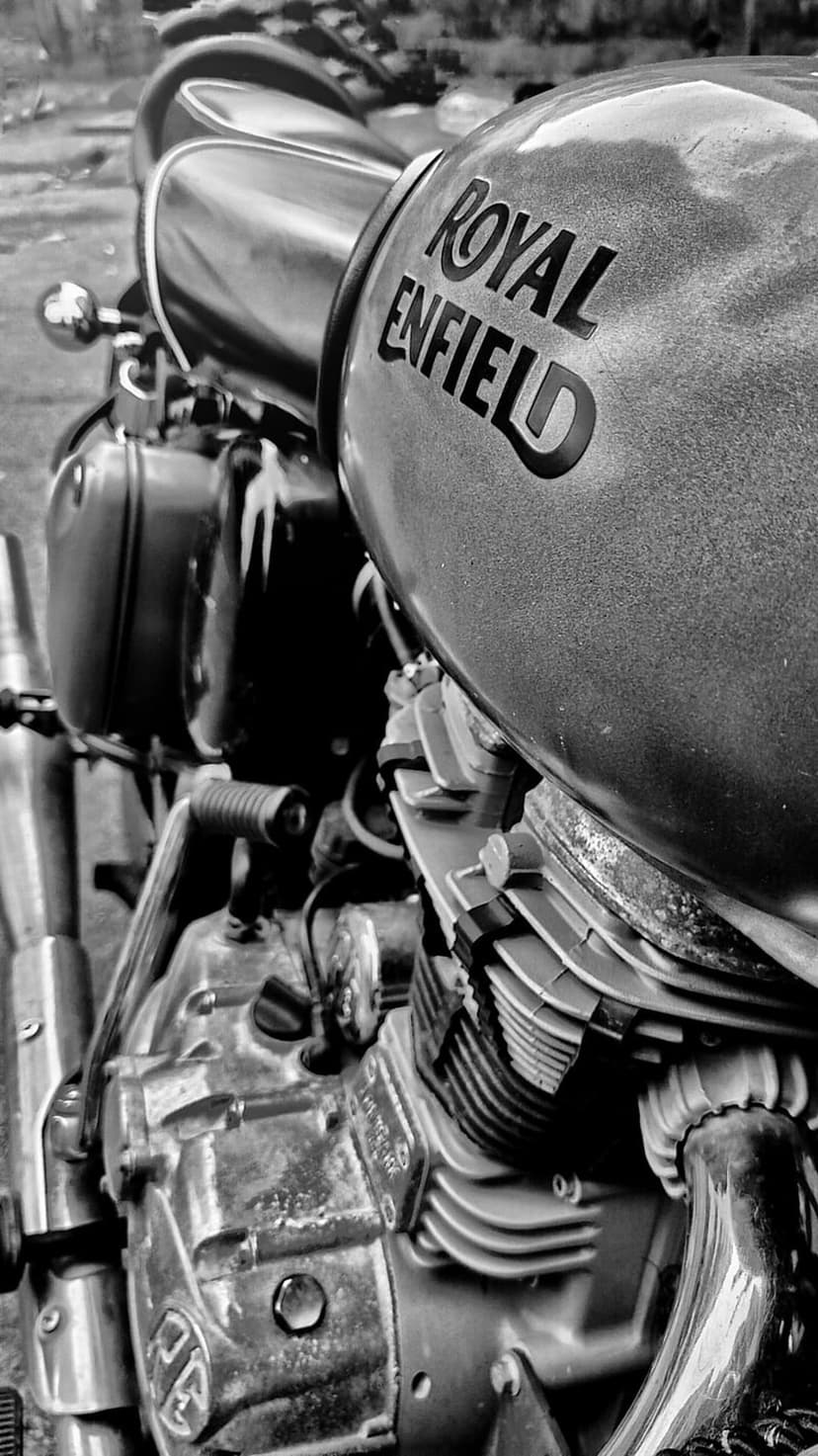 Royal Enfield motorcycle engine block and textured fuel tank shown in high-contrast black and white photography.
