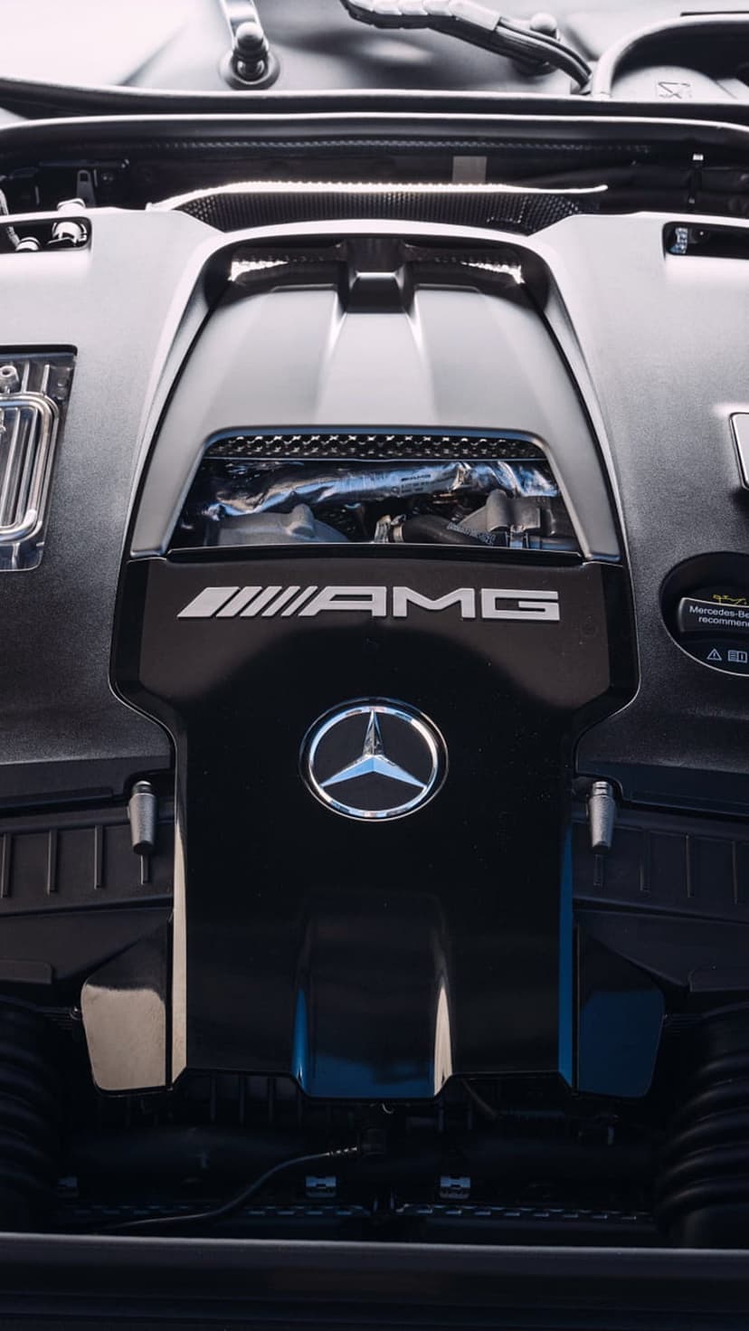 Mercedes-AMG engine bay featuring a silver three-pointed star emblem on a dark textured performance motor cover.