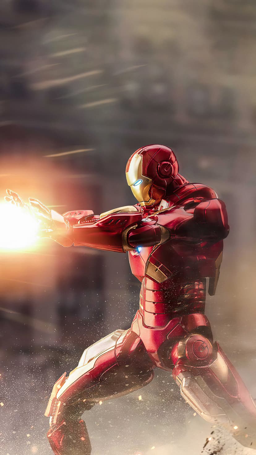 Iron Man fires a glowing repulsor blast from his palm while wearing red and gold armor amidst orange sparks.