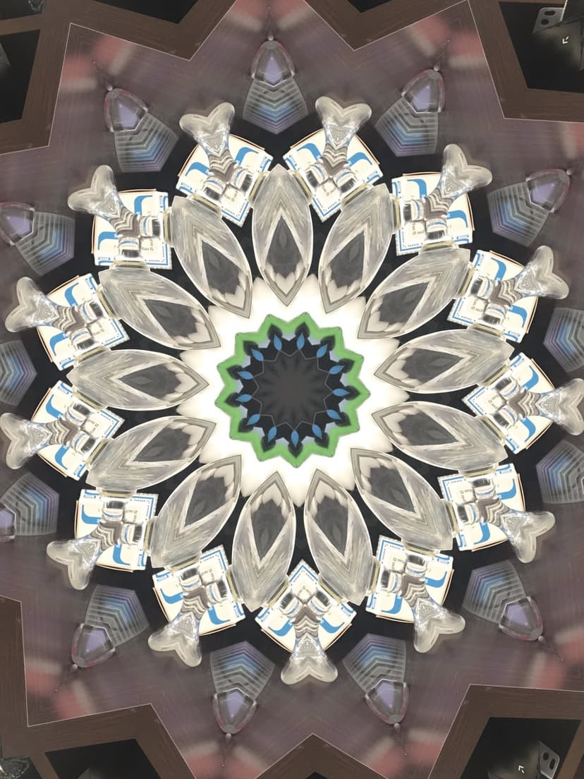 Green and silver kaleidoscope mandala featuring intricate geometric patterns and a central starburst design.