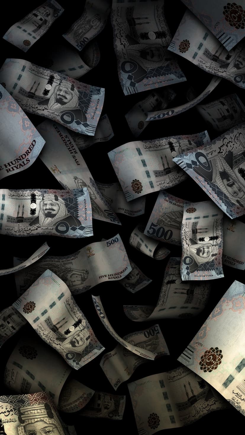 Five hundred Saudi Riyal banknotes falling in a scattered arrangement against a solid black background.