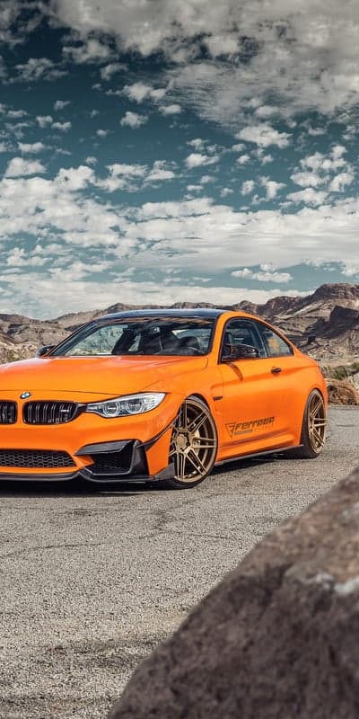 Orange BMW M4 Coupe in Desert Landscape with Custom Wheels