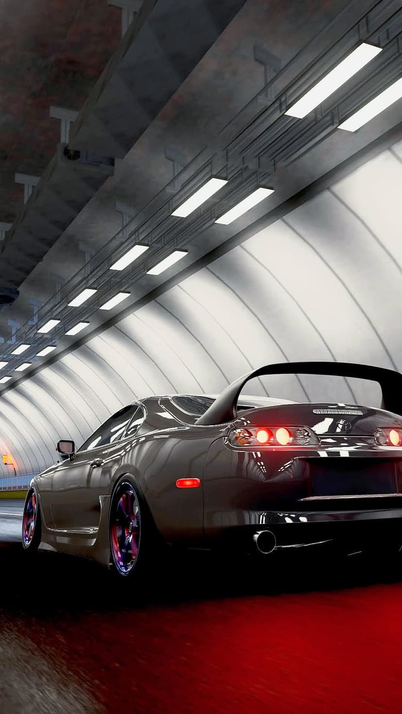 Red sports car drives through a dark tunnel with glowing taillights and reflections on wet asphalt pavement.