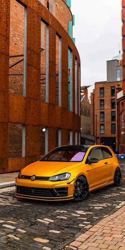 Yellow VW Golf GTI on Cobblestone Street