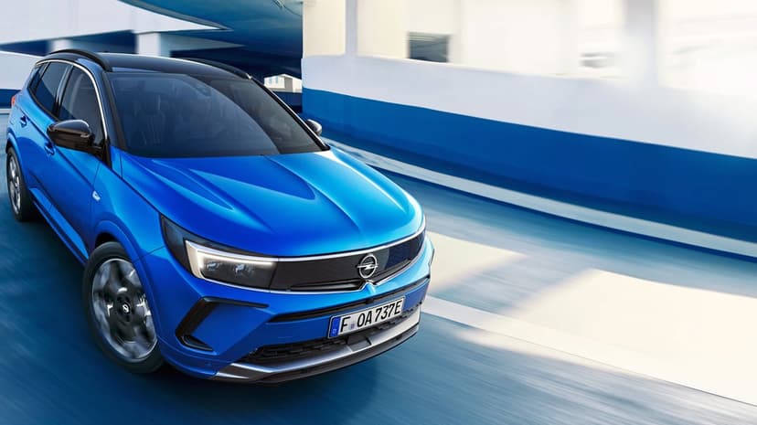 Blue Opel SUV driving fast through an urban tunnel with motion blur and sharp LED headlights.