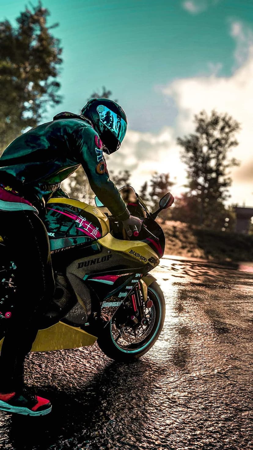 Motorcyclist in a sleek jacket and helmet sits on a sportbike over wet asphalt with glowing road reflections.