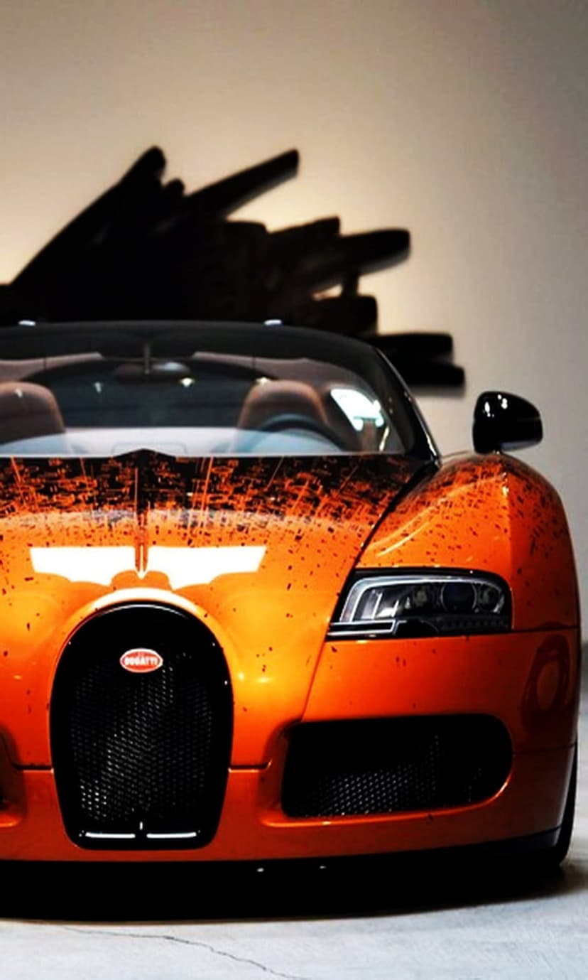 Bugatti Veyron front view featuring orange paint with abstract splatters and a distinctive horseshoe grille.
