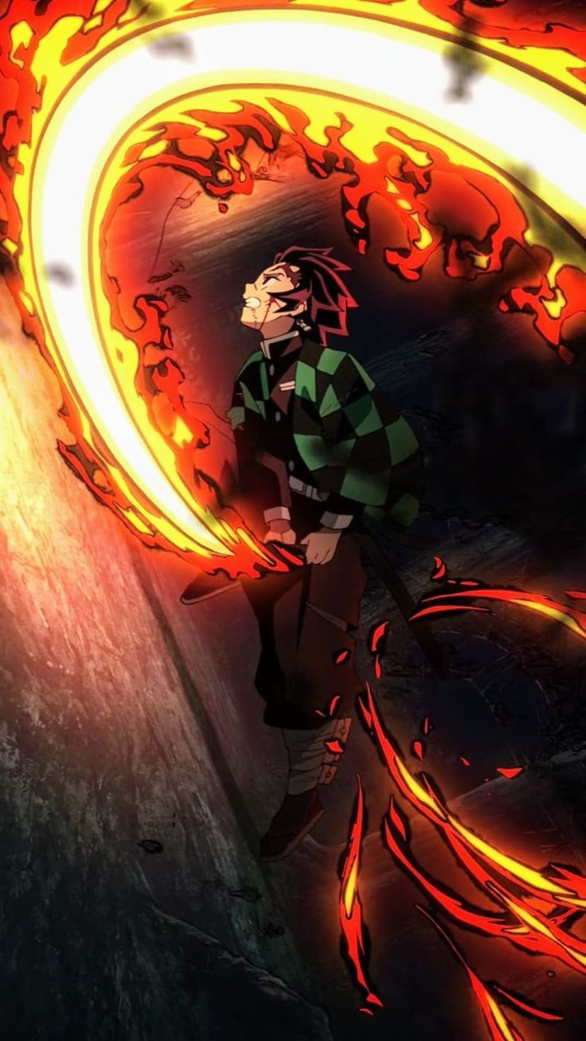 Tanjiro Kamado grips a black sword engulfed in swirling orange fire while crouching on dark, jagged rocks.