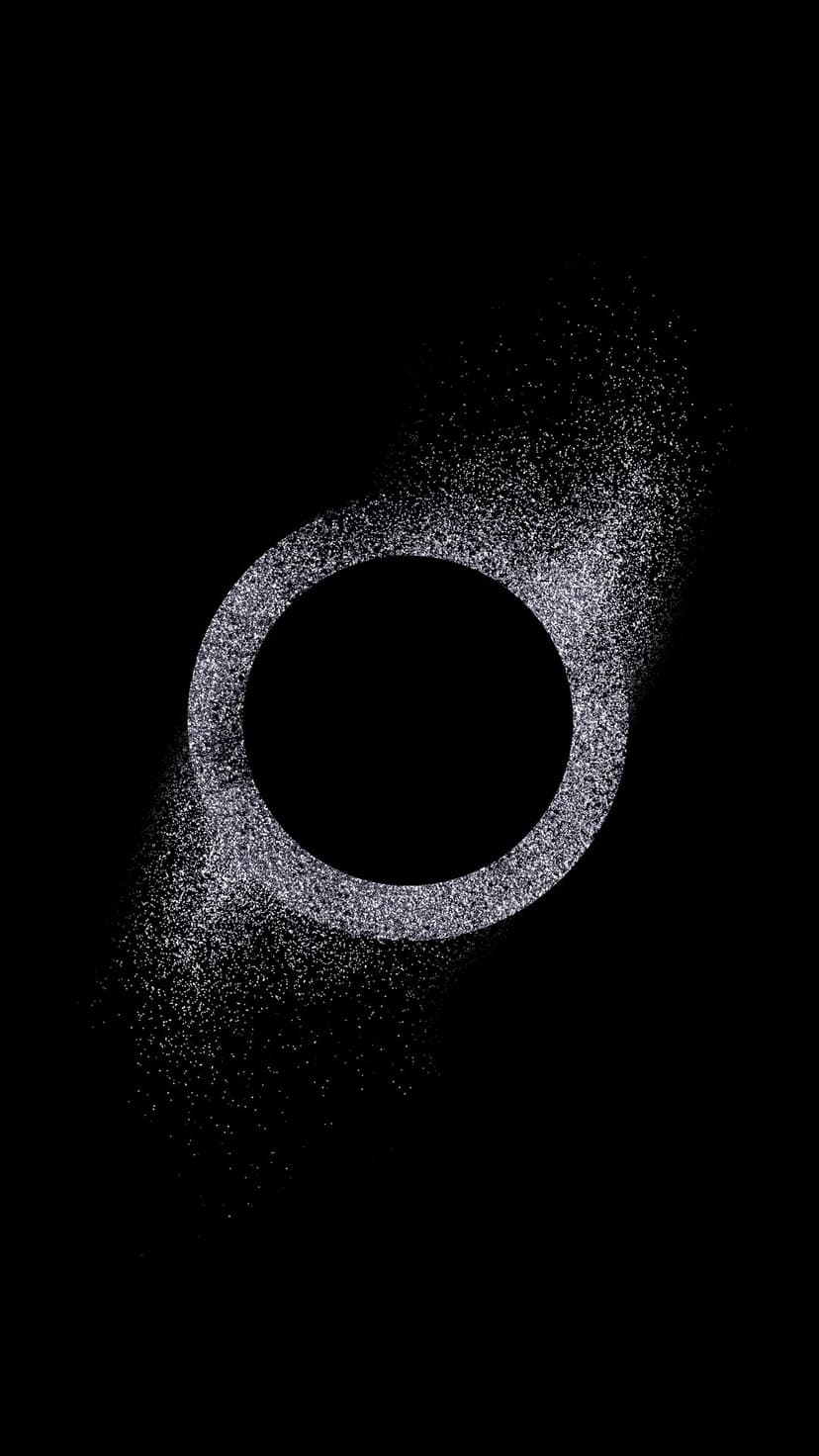 Silver glitter ring with trailing particles glows against a solid black background in a vertical format.