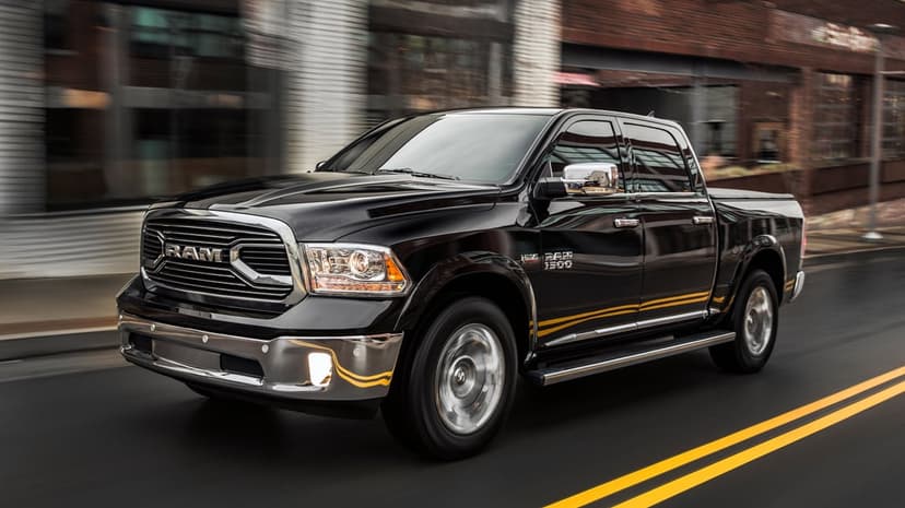 Black RAM 1500 truck driving on a wet urban road with motion blur and chrome accents reflecting city lights.