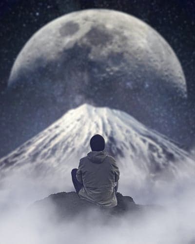 Lone Figure Watching Massive Moon Atop Snowy Mountain Peak