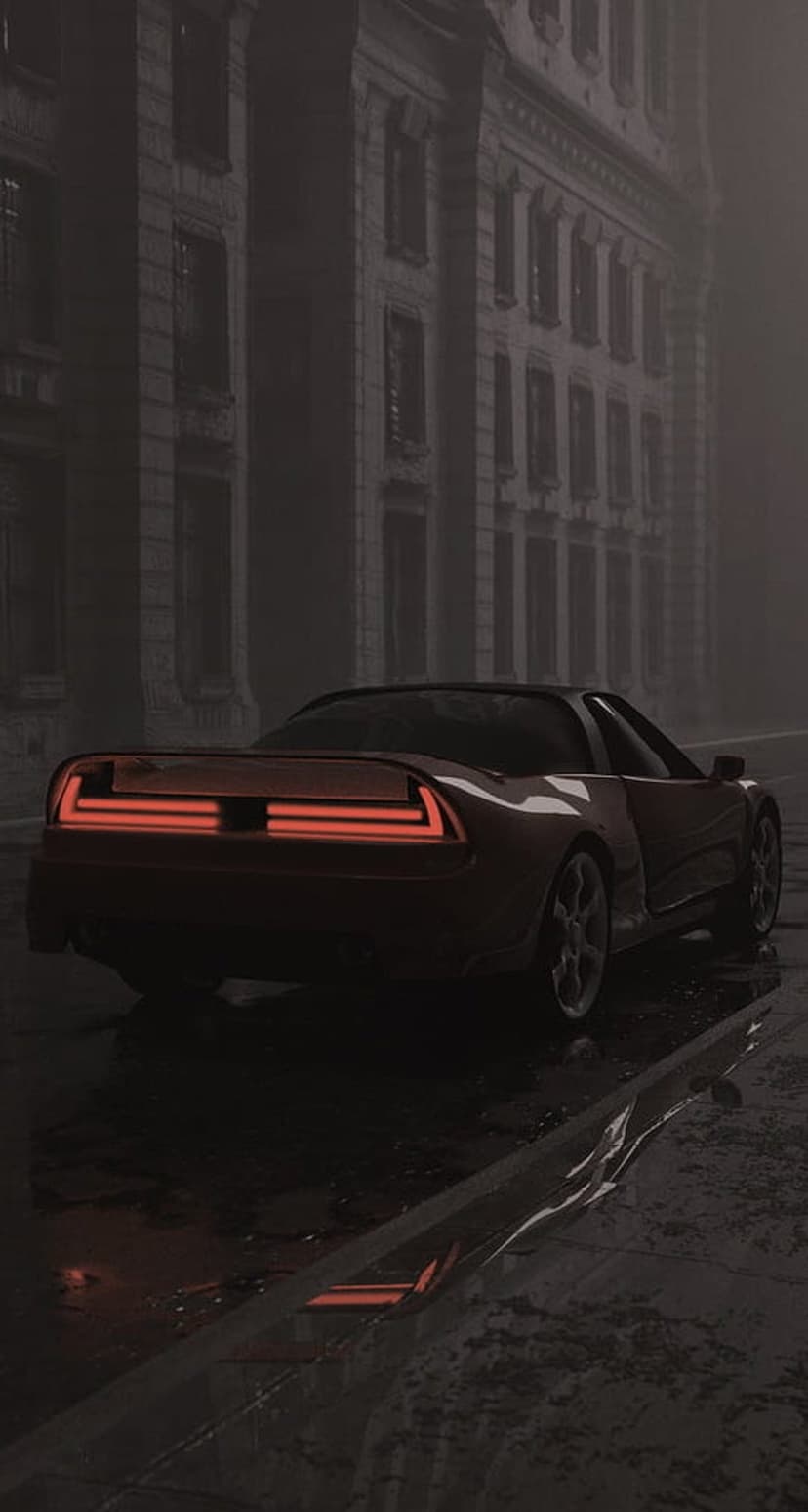 Red vintage sports car with glowing taillights parked on a wet, foggy urban street surrounded by dark buildings.