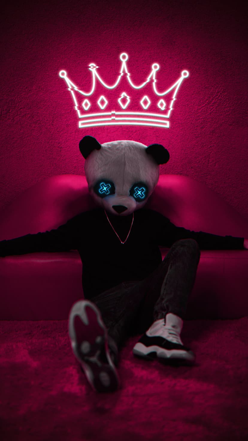 Panda bear with glowing blue cross eyes wearing a sweater and chain sits on a pink couch below a neon white crown.