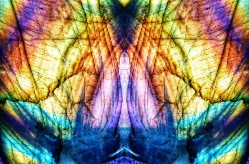 Labradorite gemstone macro showing iridescent blue and purple crystalline fractures with golden light reflections.