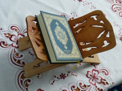 Quran on wooden stand with ornate cover