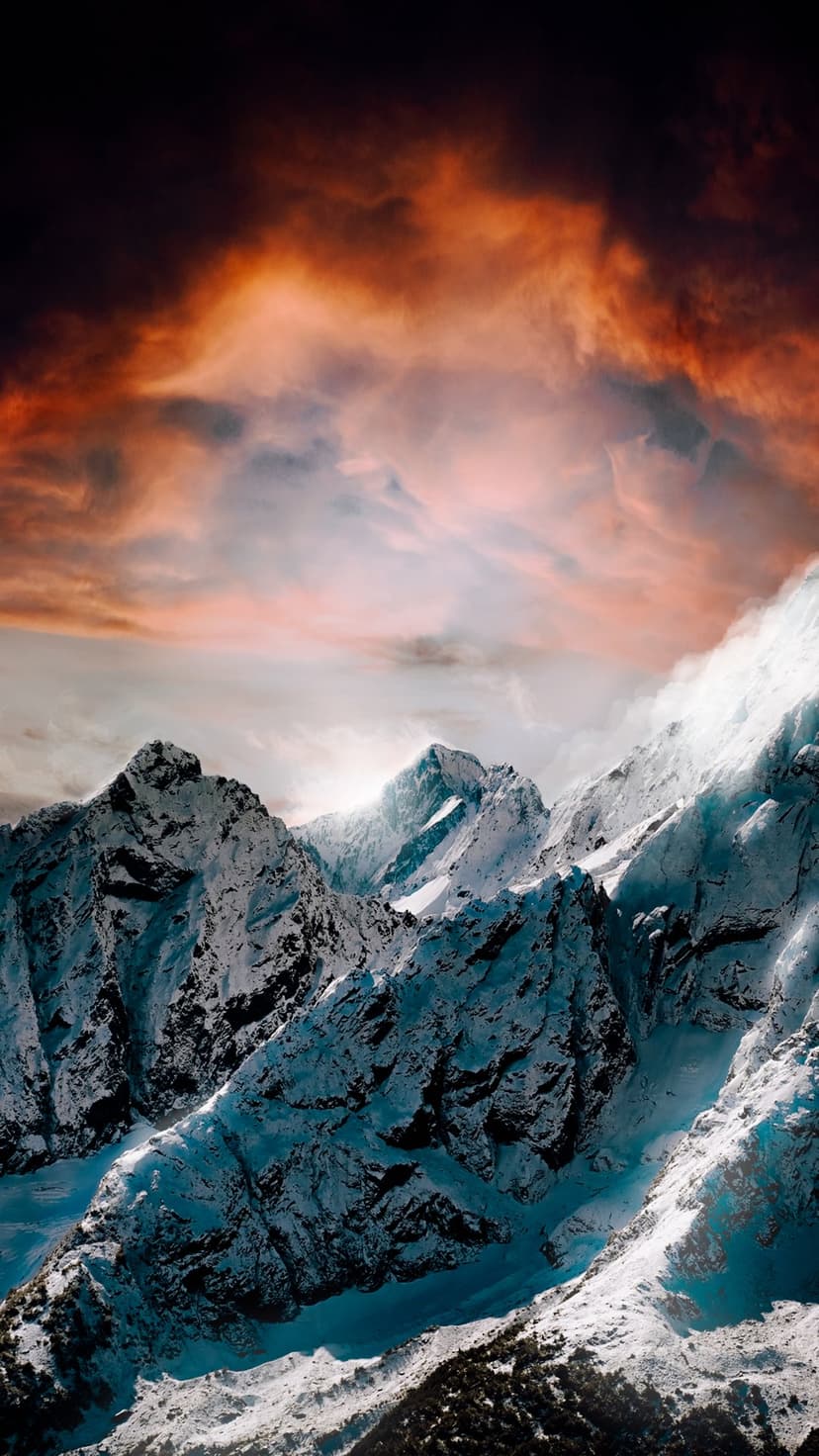 Snow-covered mountain summits reflect a fiery orange sunset sky above deep blue shadows in a vertical landscape.