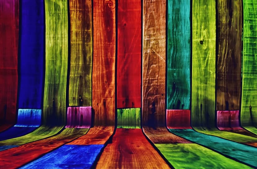Multicolored wooden planks in vertical and horizontal orientations featuring a saturated rainbow spectrum of paint.