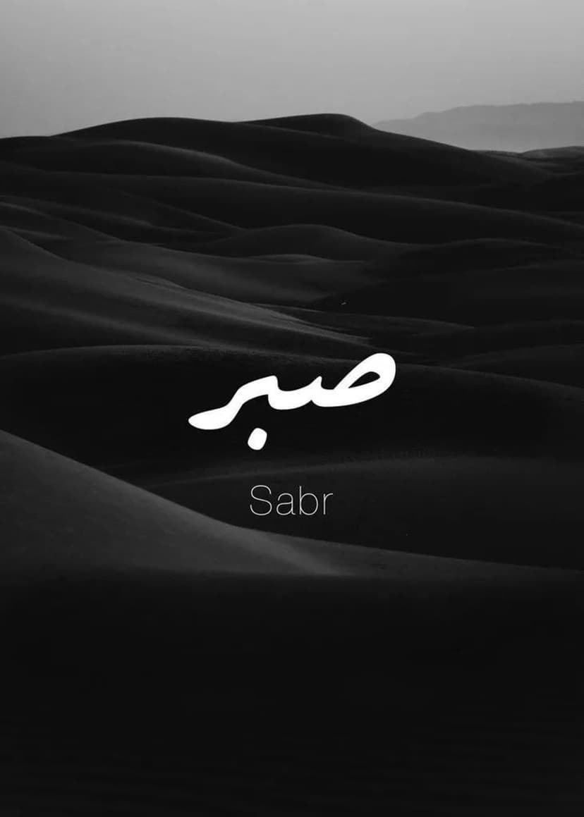 White Sabr Arabic calligraphy sits centered above dark undulating desert sand dunes in a monochrome view.