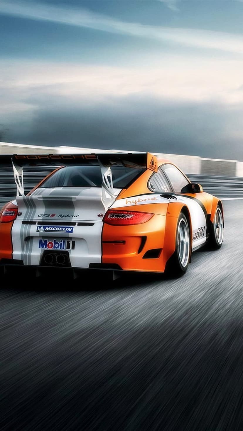 Porsche GT3 R Hybrid race car with white and orange livery speeds on a blurred track under a dramatic cloudy sky.