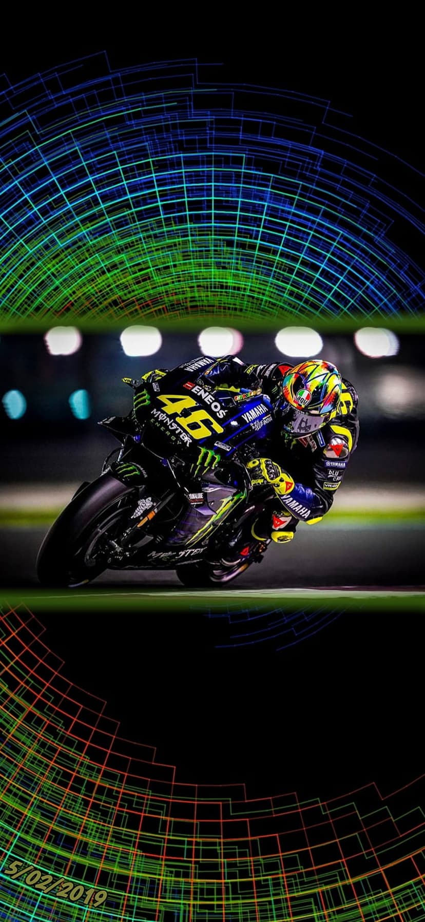 Valentino Rossi in blue leathers leans his number 46 Yamaha motorcycle into a turn with neon circular overlays.