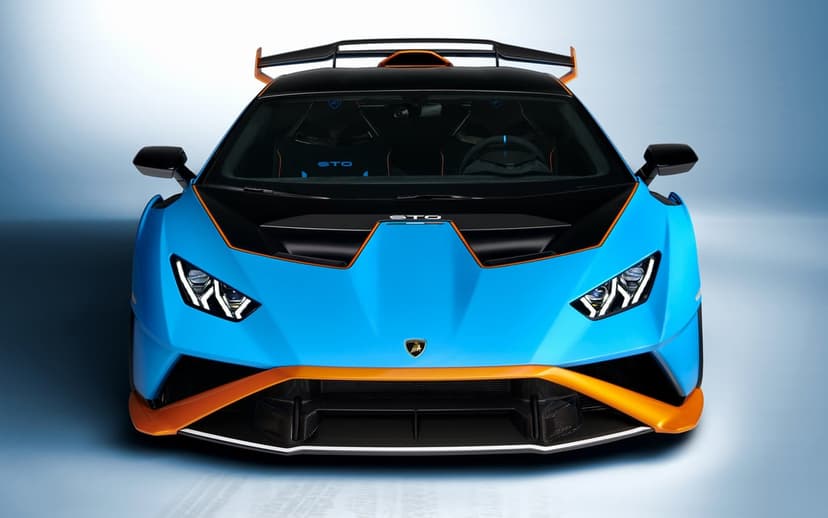 Lamborghini Huracan STO in blue and orange with aggressive aero and LED headlights in a studio setting.