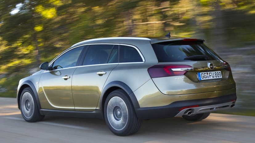 Golden Opel Insignia Country Tourer driving on a tree-lined road with motion blur and warm metallic lighting.