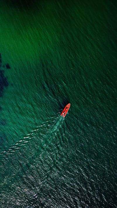 Emerald Voyage- Solitary Boat on Azure Waves