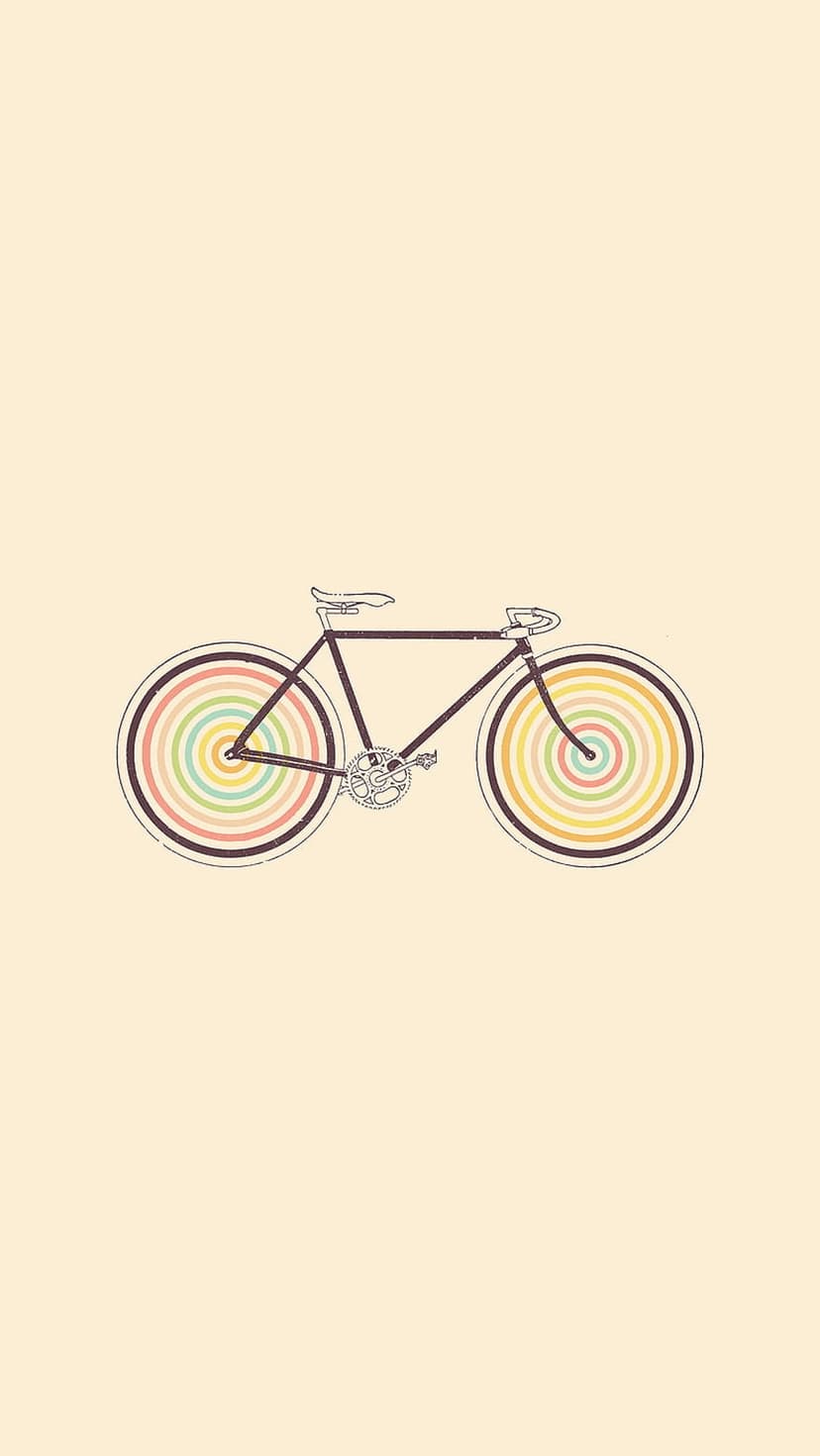 Vintage bicycle with dark frame and rainbow concentric circle wheels centered on a solid cream background.