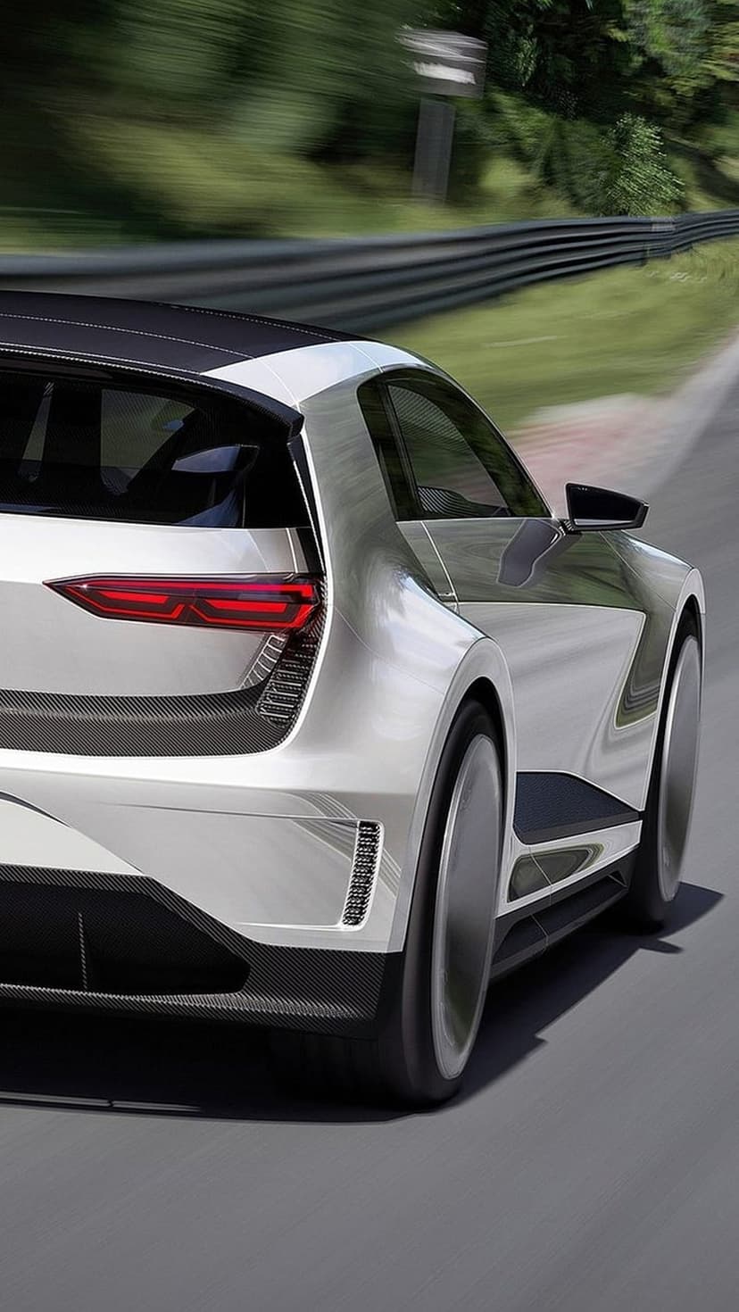 Silver concept car with glowing red LED taillights speeding past a blurred race track background in daylight.