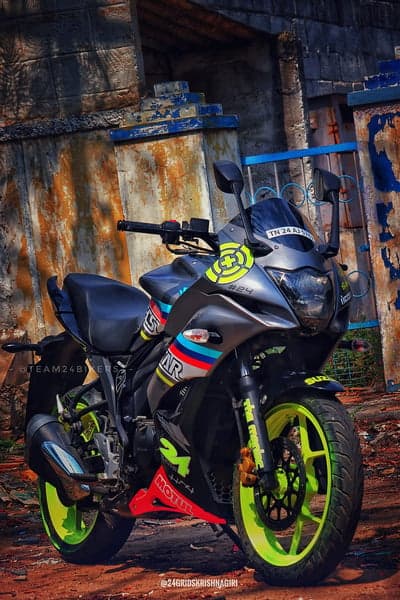 Customized Suzuki Gixxer SF with vibrant decals and lime green wheels