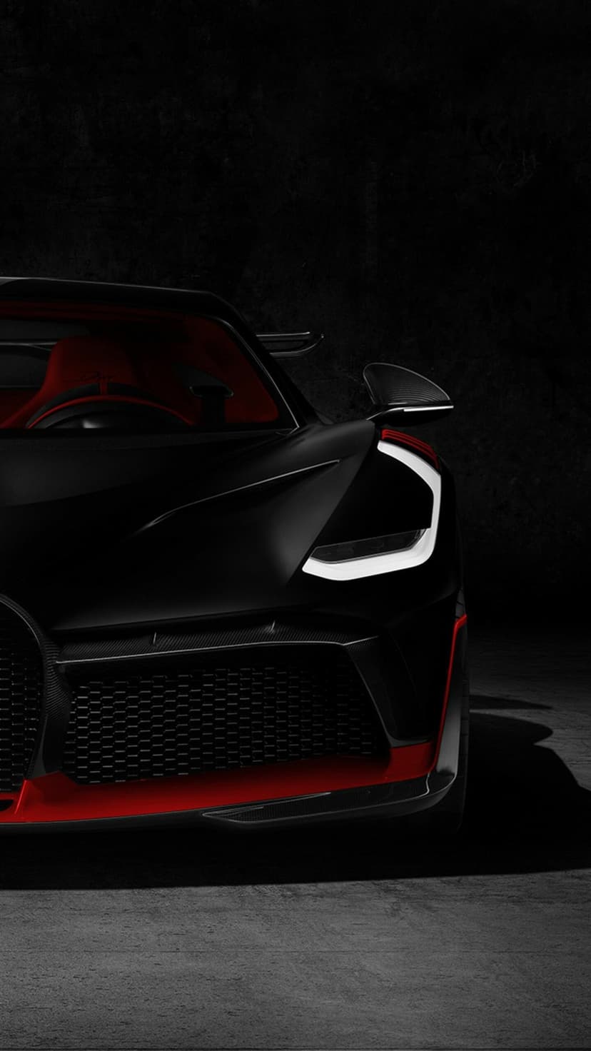 Front view of a matte black Bugatti Divo with a white LED headlight, red splitter, and luxury red interior.