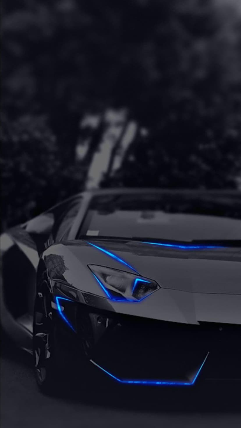 Black supercar with electric blue light accents on the bumper and headlights parked against a dark forest edge.