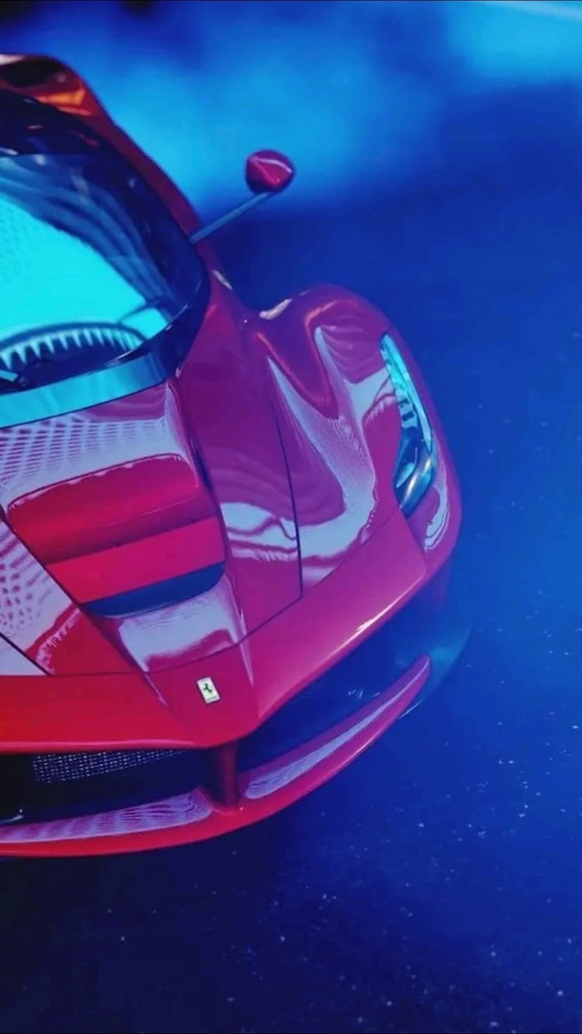 Red Ferrari hood and front fender featuring a yellow badge and vibrant blue sky reflections on the polished paint.