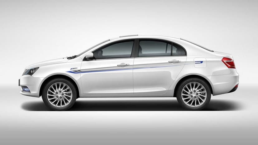 White modern sedan side profile with blue decals and silver alloy wheels against a grey studio backdrop.