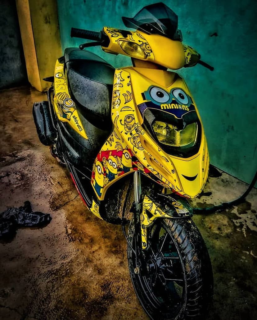 Yellow scooter featuring Minion character graphics and custom bodywork decals in a vertical portrait view.