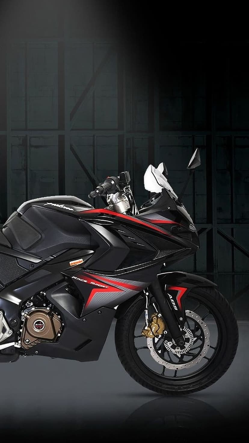 Black sportbike with red fairings and ABS disc brakes parked against a dark, industrial warehouse background.