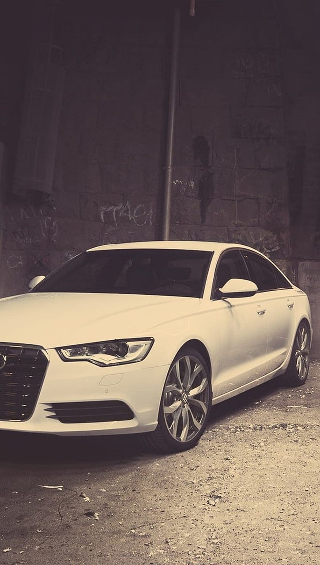 White Audi A6 sedan parked in a dark graffiti alley with sepia lighting and detailed premium alloy wheels.