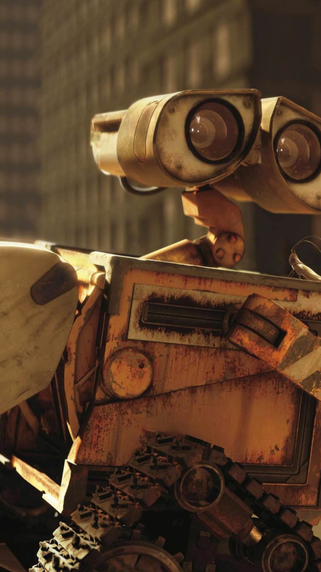 WALL-E robot with rusted binocular eyes stands amidst a dusty, desolate landscape of debris and scrap metal.
