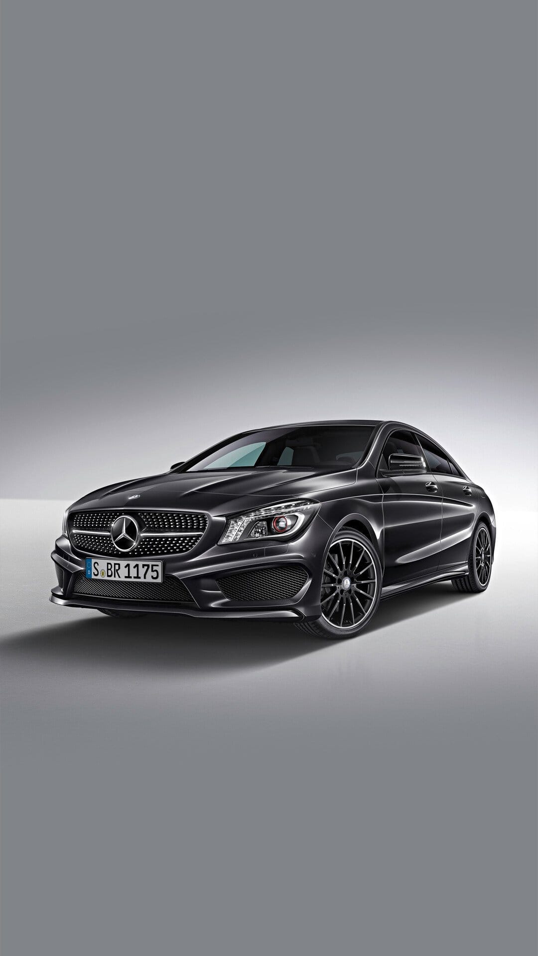 Black Mercedes-Benz CLA luxury sedan with diamond grille and multi-spoke wheels in a gray studio environment.