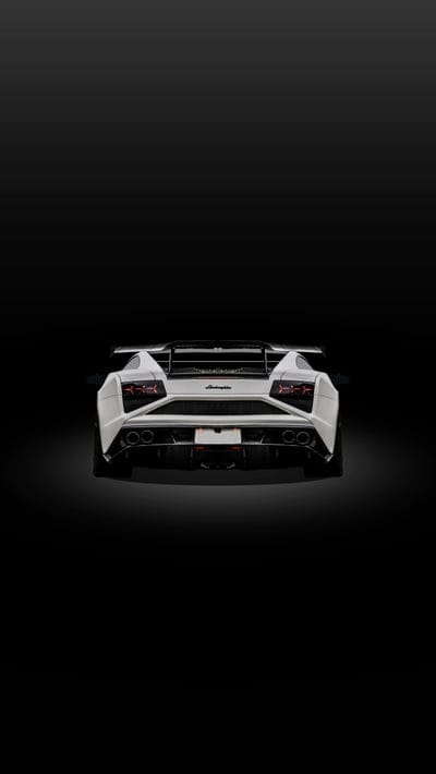 White Lamborghini Gallardo rear wing and taillights against a dark studio background for a phone lock screen.