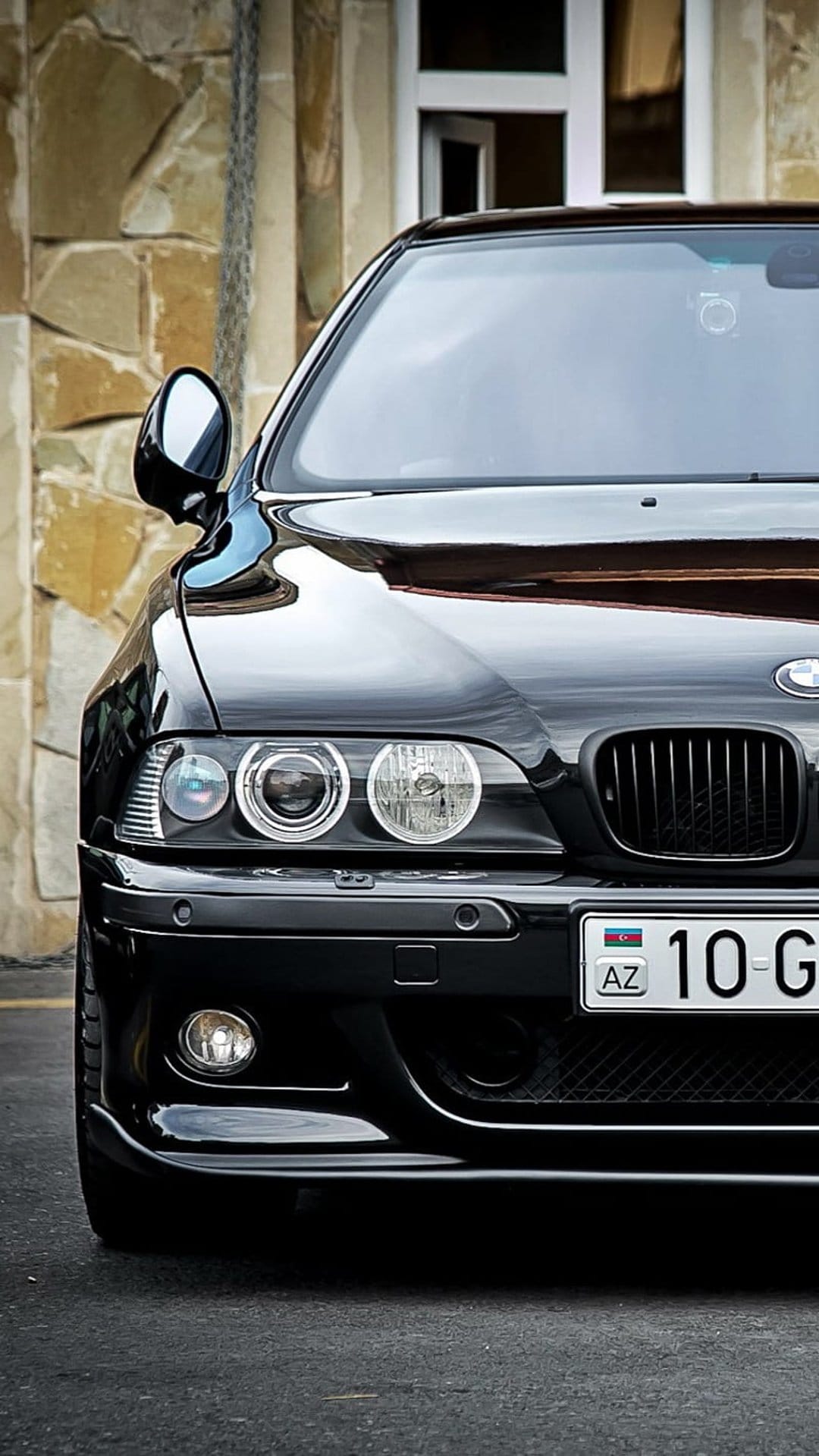 Black BMW E39 M5 front view featuring angel eye headlights, kidney grilles, and an Azerbaijani license plate.