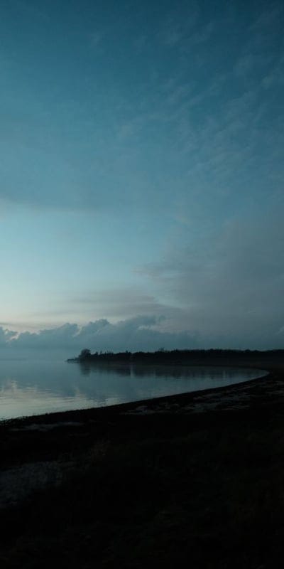 Waterfront, Dawn, Cloudy, Misty, Tranquil, Coastal, Serene, Reflective, Nature, Horizon, Blue Hues, Outdoors, Peaceful, Landscape, Quiet, Morning, Evening, Shoreline, Atmospheric, Calm