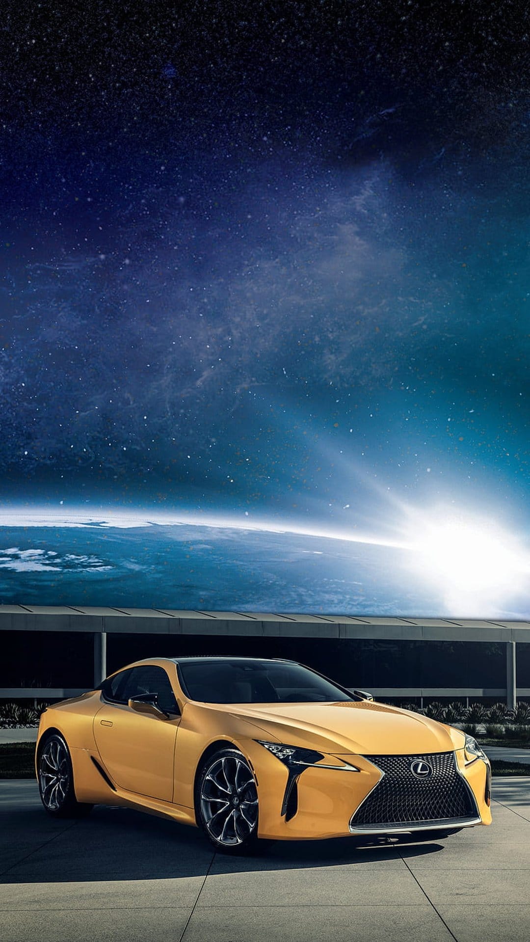 Yellow Lexus LC coupe parked on a patio facing a sunrise over planet Earth with a starry space background.