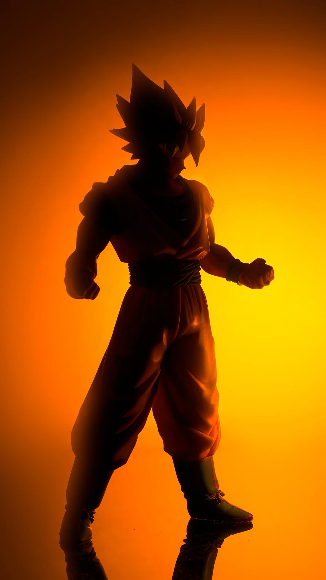 Goku silhouette stands centered against a brilliant explosion of orange and yellow backlighting and energy.