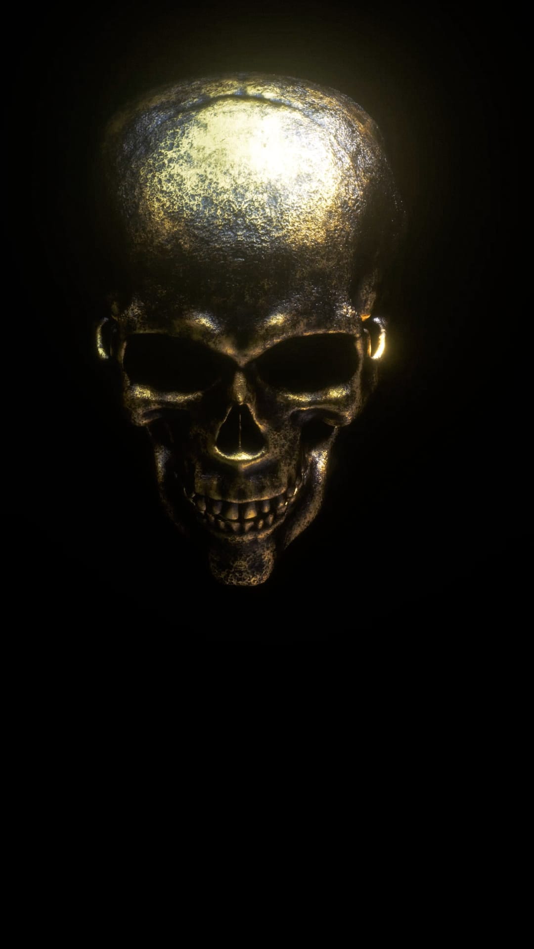 Weathered golden skull with faintly glowing eyes and detailed teeth centered on a deep black background.