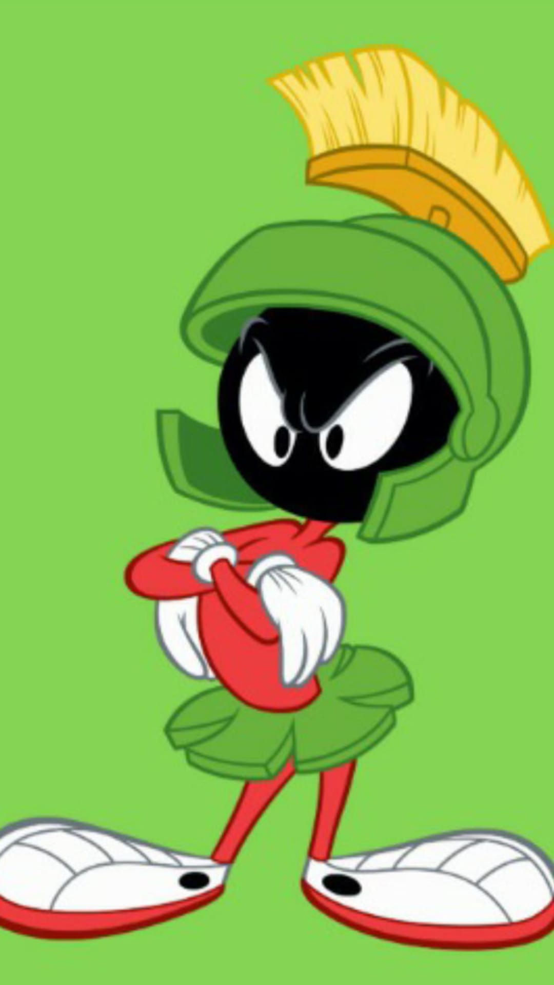 Marvin the Martian wears a green helmet and red tunic with arms crossed against a lime green backdrop.